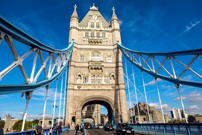 Low angle view of suspension bridge against blue sky