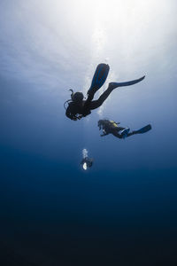 Friends with diving equipment in blue sea