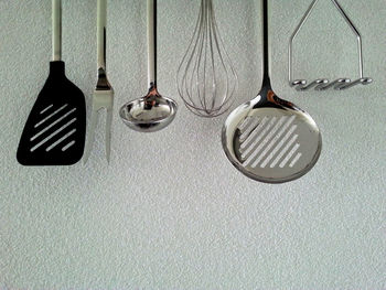 Close-up of kitchen utensils hanging from wall