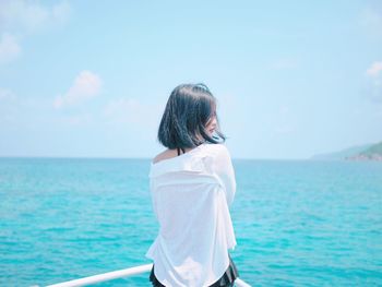 Rear view of woman looking at sea against sky