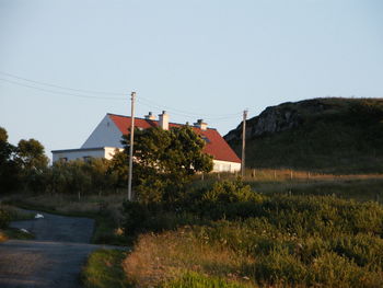 Houses by trees against sky