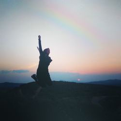 Full length of woman jumping against sky 