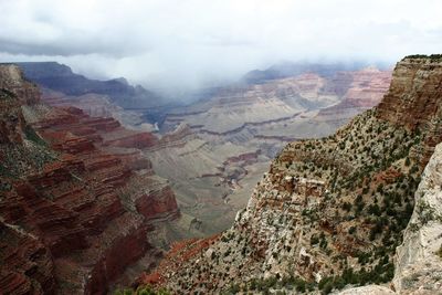 Aerial view of rock formations against cloudy sky