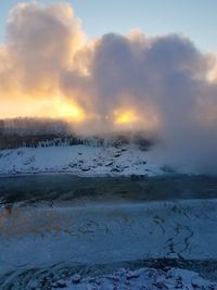 Scenic view of snow covered landscape against sky during sunset