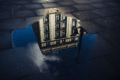 Reflection of building in puddle on street