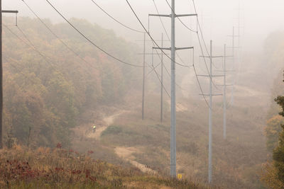 Electricity pylon on mountain in foggy weather