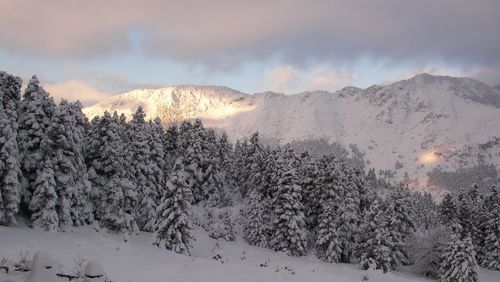 Snow covered mountain against cloudy sky