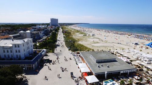 High angle view of people on beach by buildings against sky