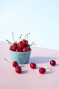 Fresh and juicy cherries in a ceramic bowl on a pastel pink background. copy space. seasonal summer 