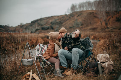 Lovers in the fall on the camp take a selfie on a smartphone