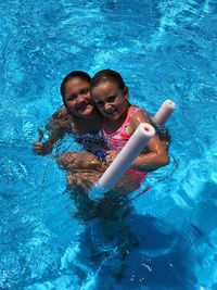 Portrait of sisters swimming in pool