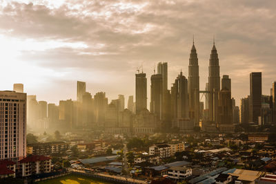 Modern buildings in city against cloudy sky