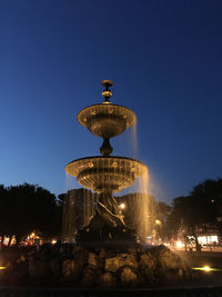 Illuminated fountain against clear sky at night