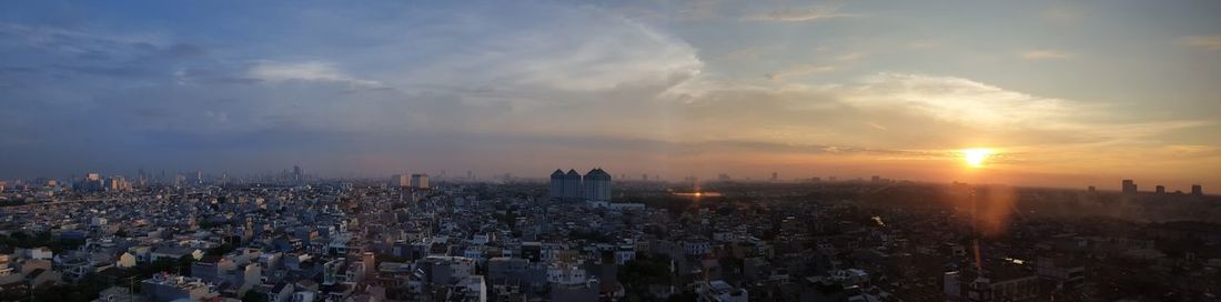 High angle view of city buildings against sky during sunset