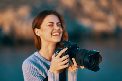 Portrait of a smiling young woman with camera