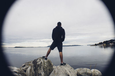 Rear view of man standing on pier