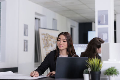 Young businesswoman using laptop at home