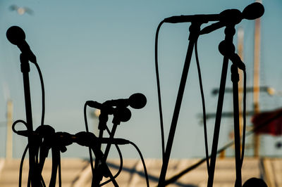 Silhouette microphones against sky