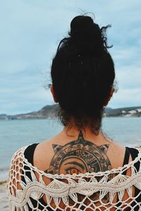 Rear view of woman looking at sea against sky