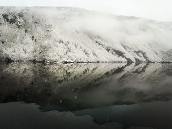 Scenic view of lake against sky during foggy weather