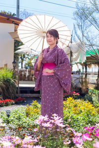 Woman standing by flowering plants