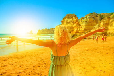 Woman enjoying at beach against sky