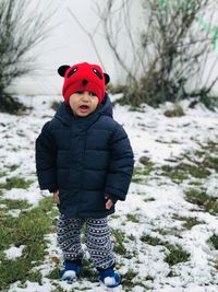 Full length of boy standing on snow covered land during winter