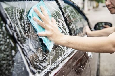 Close-up of man washing car