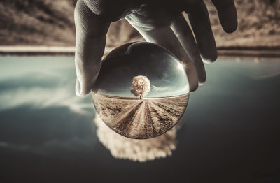 Close-up of hand holding water in lake