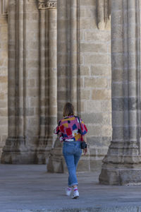 Full length of woman standing against building