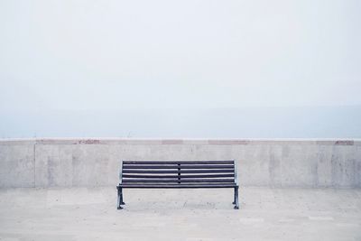 Chair on sea against clear sky