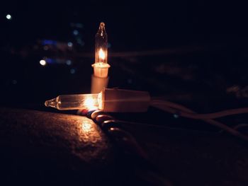 Close-up of lit candle in the dark