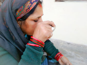 Close-up of woman drinking drink from bowl outdoors