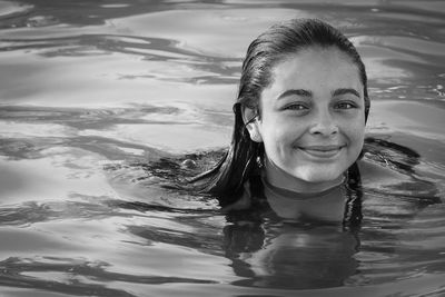 Portrait of smiling young woman swimming in pool