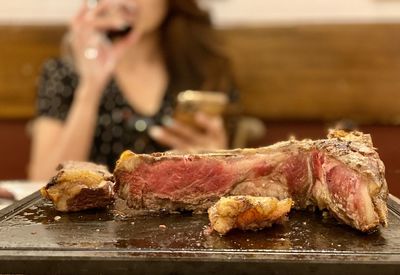 Close-up of woman holding food on table in restaurant