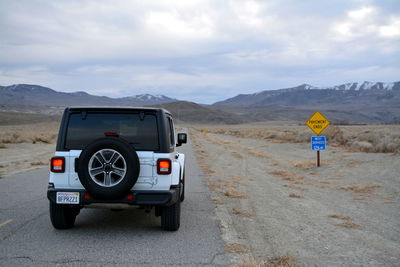 Vintage car on road against mountains