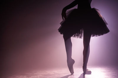 Low section silhouette ballet dancer dancing on stage