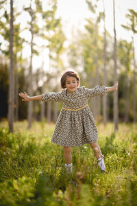 Girl with arms outstretched playing on grass