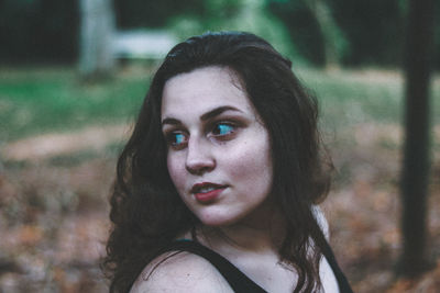 Close-up of teenage girl looking away at public park