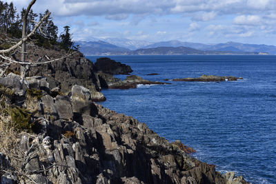 Scenic view of sea and mountains against sky