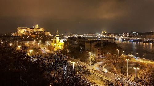 High angle view of illuminated buildings against sky at night