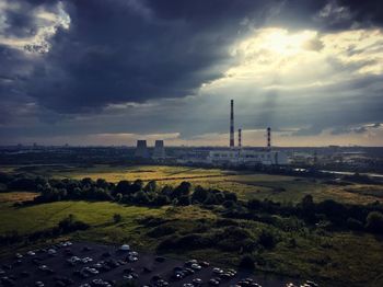 View of factory against cloudy sky during sunset