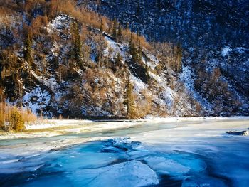 Frozen river by mountain