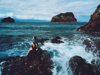 Scenic view of rocks in sea against sky