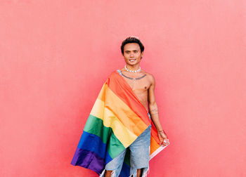 Man standing against pink wall