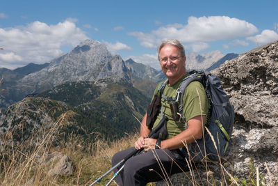 Rear view of man standing on mountain against sky