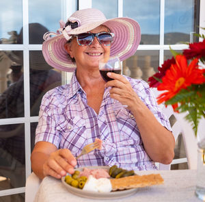 Smiling senior woman having wine at table