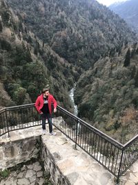 High angle view of man standing by railing against mountains