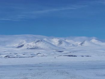 Scenic view of snowcapped mountains against blue sky