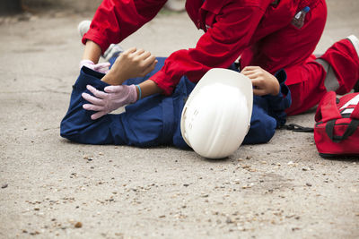 Paramedic performing cpr on person lying on street